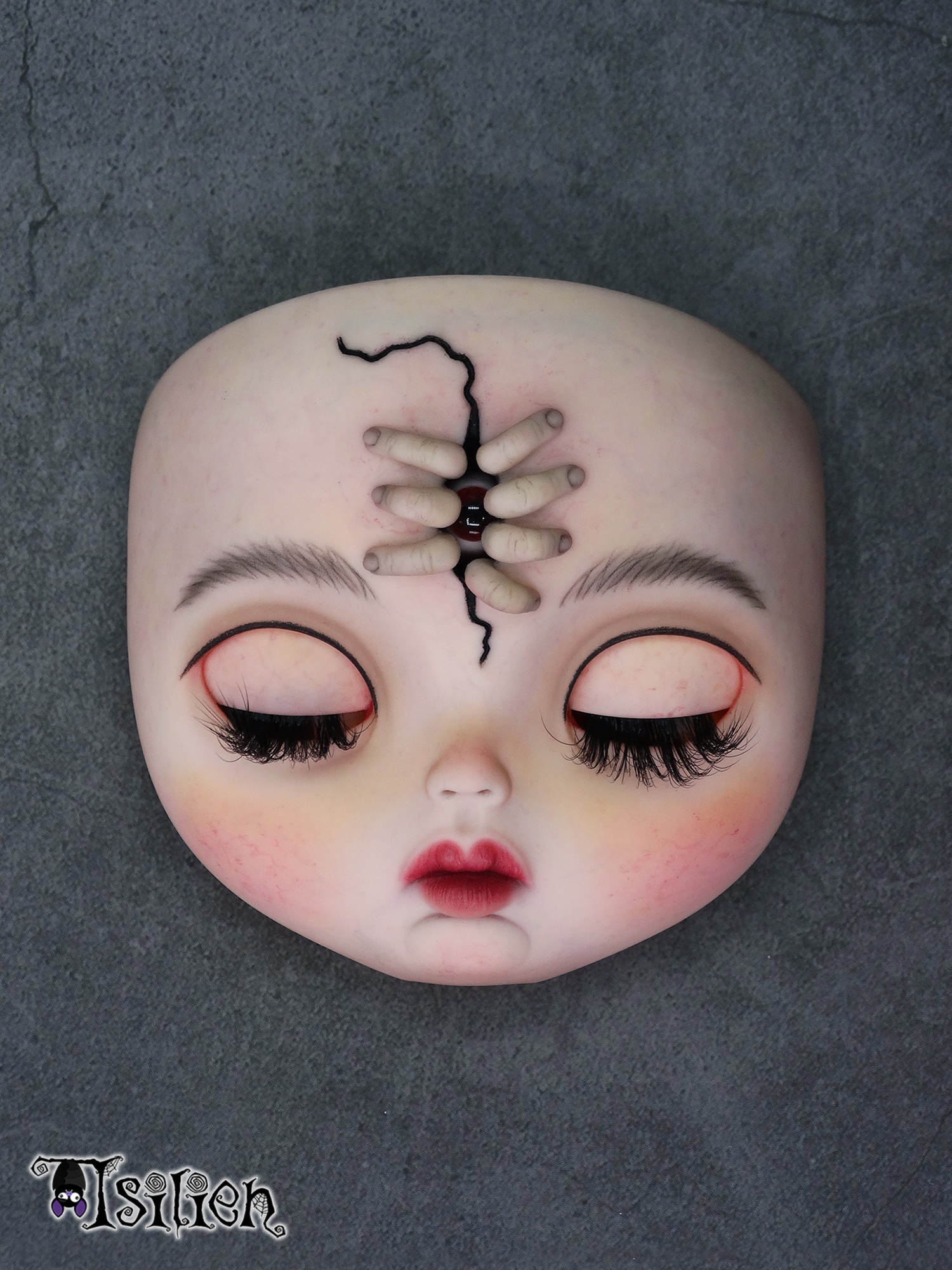 Amara, muñeca Blythe custom de aspecto siniestro y dulce, con pelo negro, vestido vintage y gorrito con orejas de conejo. Unos dedos abren una grieta en su frente, dejando ver un misterioso ojo.